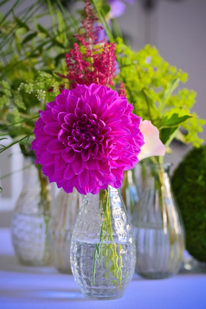 A vertical closeup shot of a small vase with beautiful purple hortensia flower